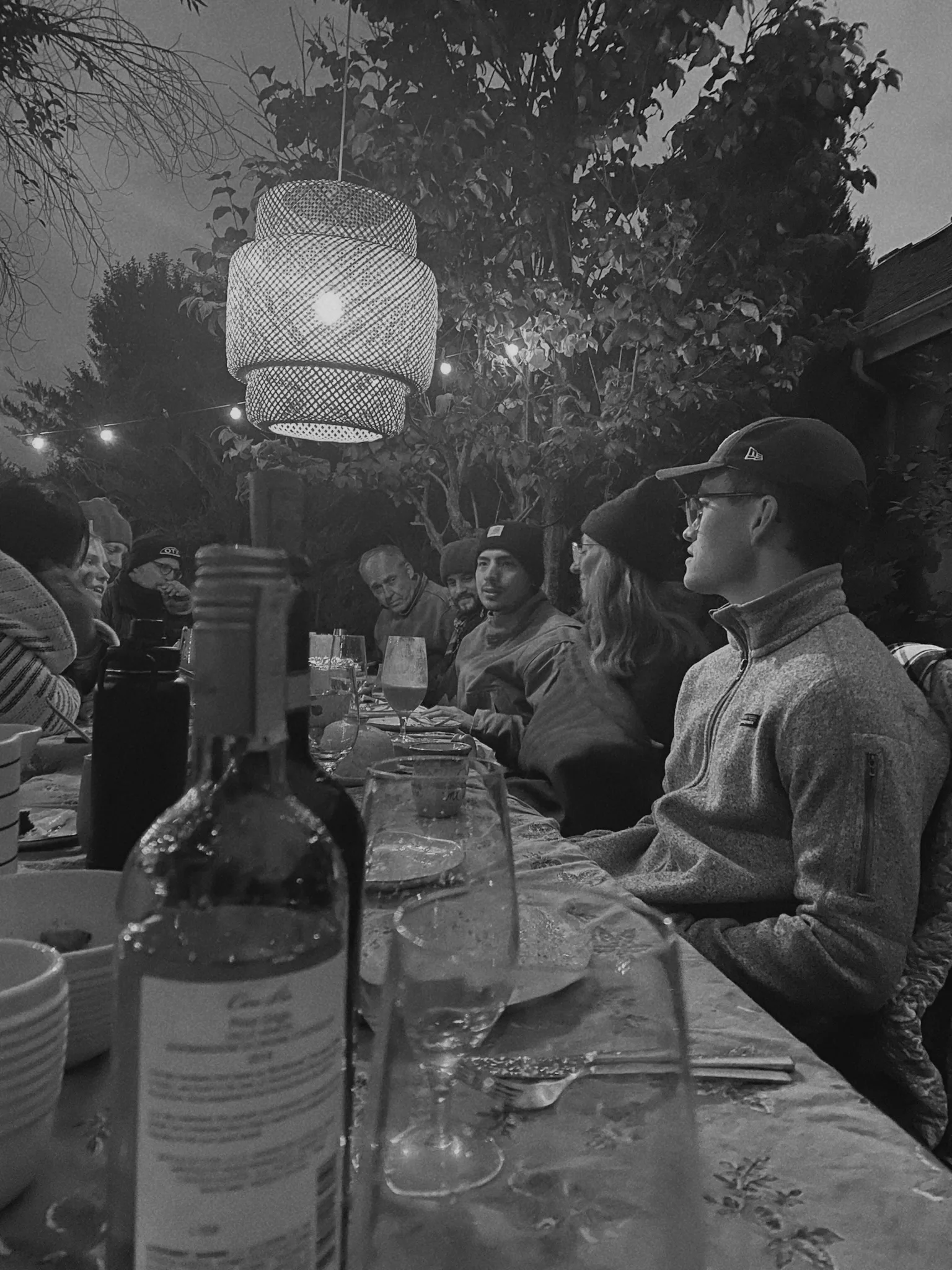 Outdoor dinner party under evening string lights