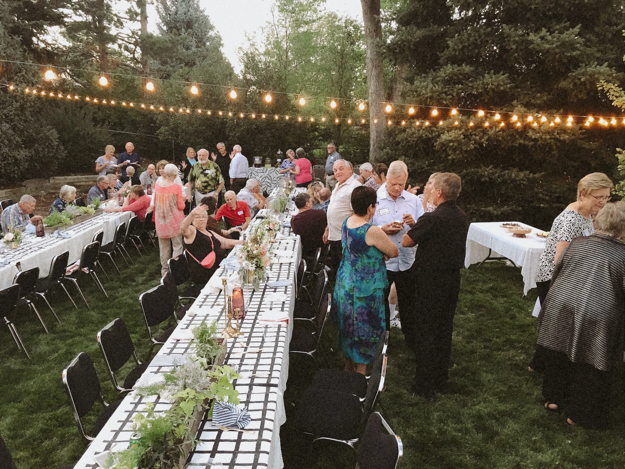 Guests mingling at a formal outdoor evening event