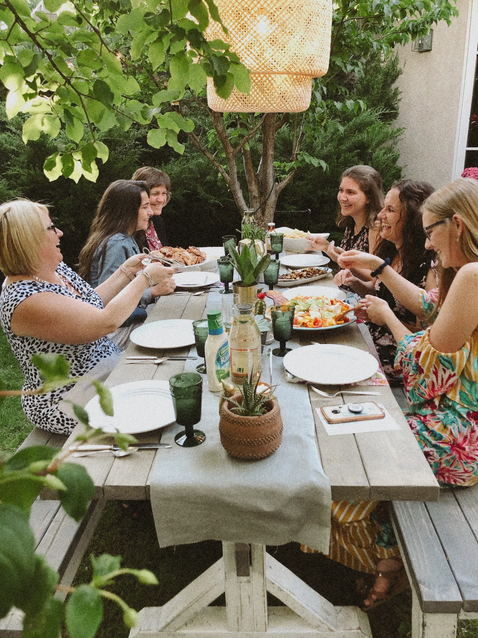 Women laughing together at outdoor picnic table